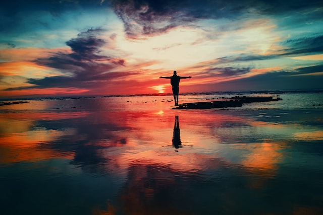 Persona su una spiaggia durante il tramonto.