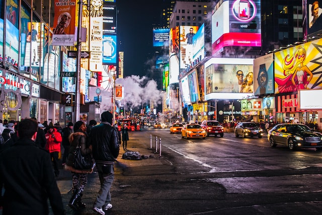 Anúncios apresentados em painéis digitais numa rua movimentada.