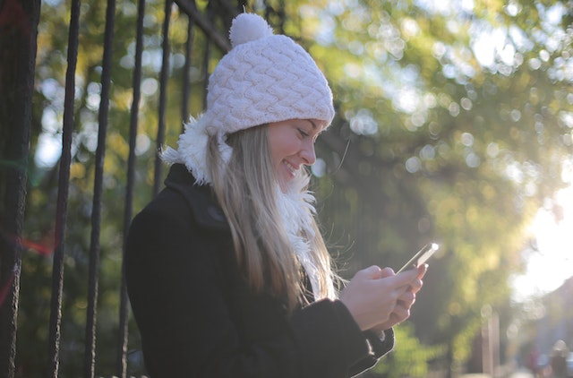 Eine Frau, die ihr Smartphone benutzt, um als anonymer Instagram Zuschauer aufzutreten.