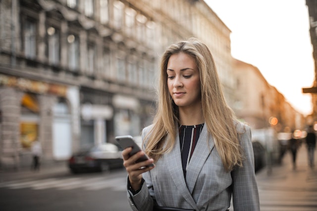 Eine Frau überprüft ihr neu verifiziertes Instagram Konto auf ihrem Telefon.