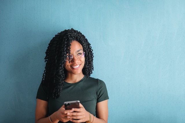 Women on her smartphone, learning how to clear Instagram cache.