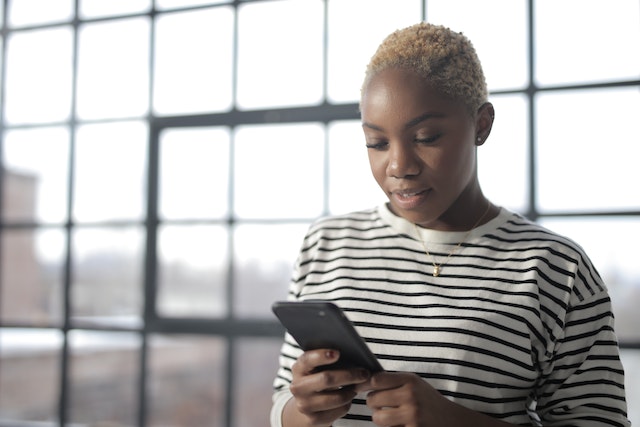 Une personne qui utilise son smartphone pour télécharger des applications afin de gagner des adeptes sur Instagram.