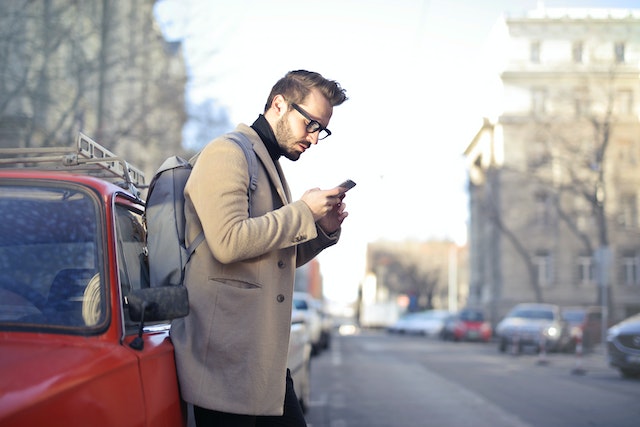 Man looking at phone to learn how to be an anonymous Instagram user.