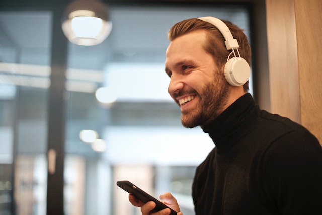 Bărbat la căști ascultând muzica pe care a adăugat-o pe povestea sa Instagram .