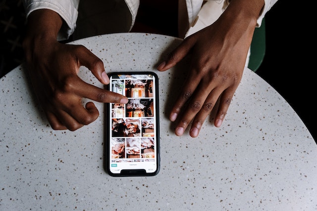 Persoon houdt telefoon vast en scrollt door Instagram.