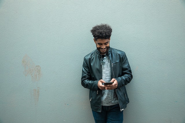 pexels-ekaterina-belinskaya-4923039 | Path Social Ein Mann steht draußen, hält ein Smartphone in der Hand und lernt, wie man einen Beitrag auf Instagram veröffentlicht.