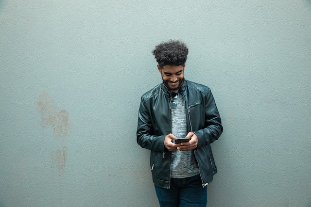 Man staat buiten met een smartphone en leert hoe hij een verhaal moet reposten op Instagram.