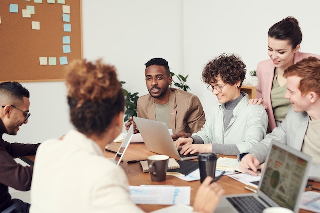 A team having a meeting about whether or not to pay for Instagram followers. 