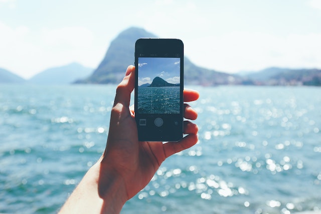 Eine Person hält ein Smartphone in der Hand, um ein Video der Aussicht aufzunehmen.