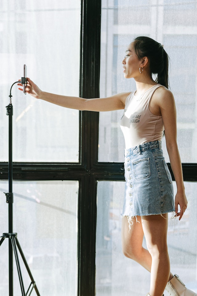 Mujer tomando una nueva Instagram Pfp con su smartphone.