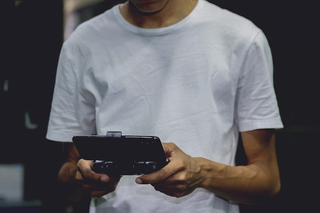 Homme jouant à des jeux Instagram sur la manette d'un téléphone intelligent.