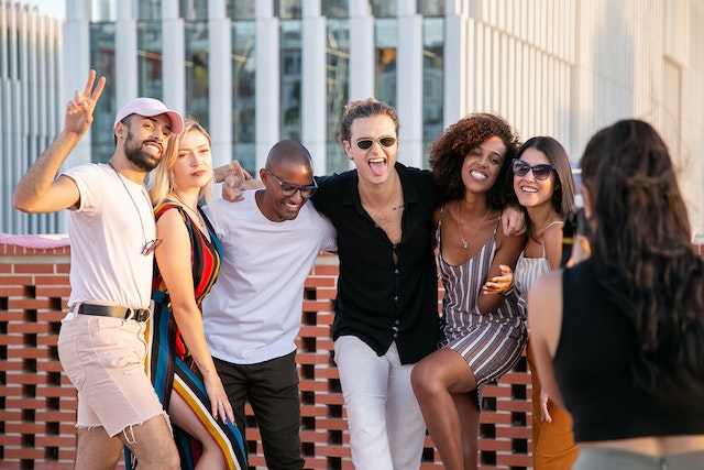 Groupe d'amis sur un toit se faisant prendre en photo.