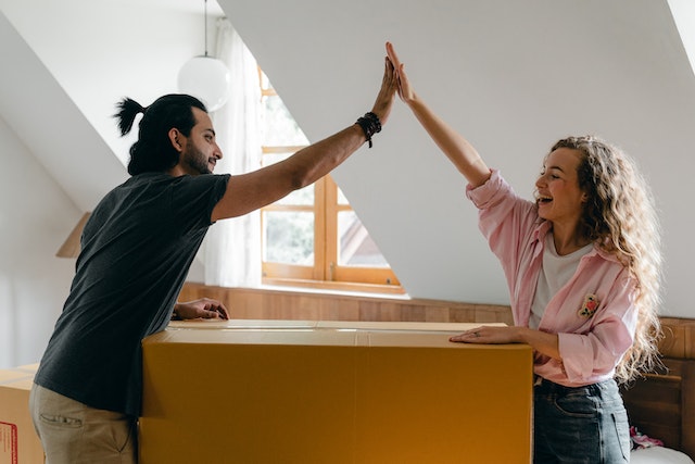 Een man en een vrouw geven elkaar een high-five voor hun succes in het vergroten van het aantal volgers door te betalen voor Instagram volgers. 