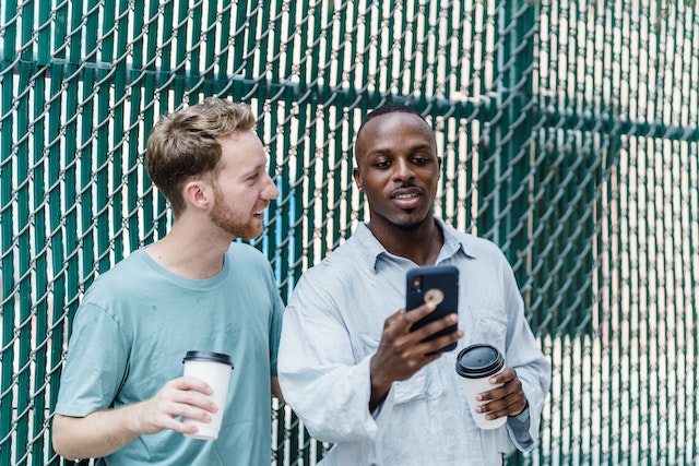 pexels-mizuno-k-13335193 | Path Social Duas pessoas a jogar Instagram num telemóvel inteligente.