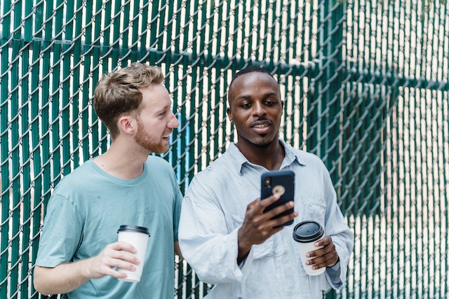 Doi oameni care se joacă Instagram jocuri pe un telefon inteligent.