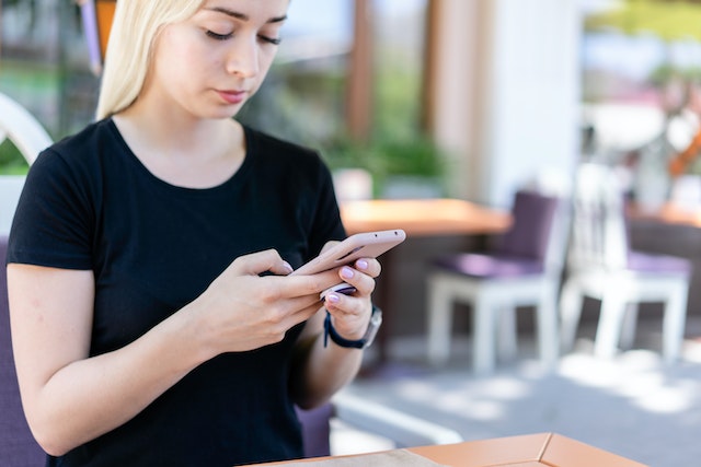 Mujeres que usan su teléfono para mirar hacia arriba Instagram opciones de agencias de crecimiento.