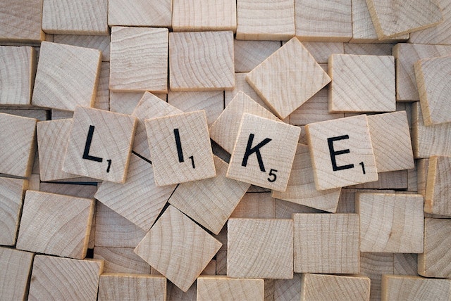 Des tuiles de Scrabble épelant &quot;LIKE&quot; sur des tuiles vierges.