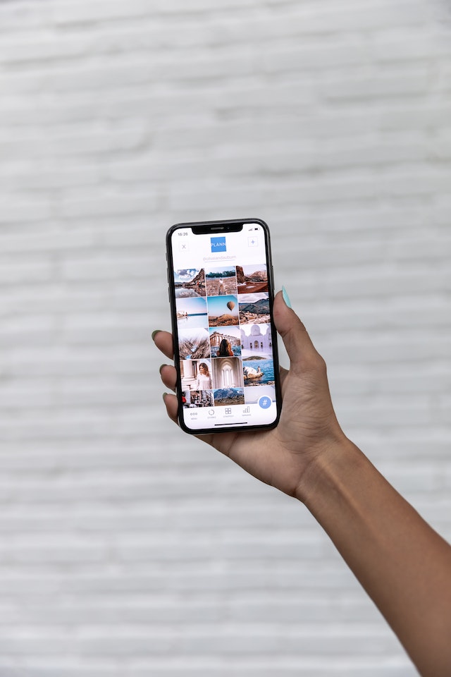 Personne tenant un smartphone ouvert sur l'application Instagram.