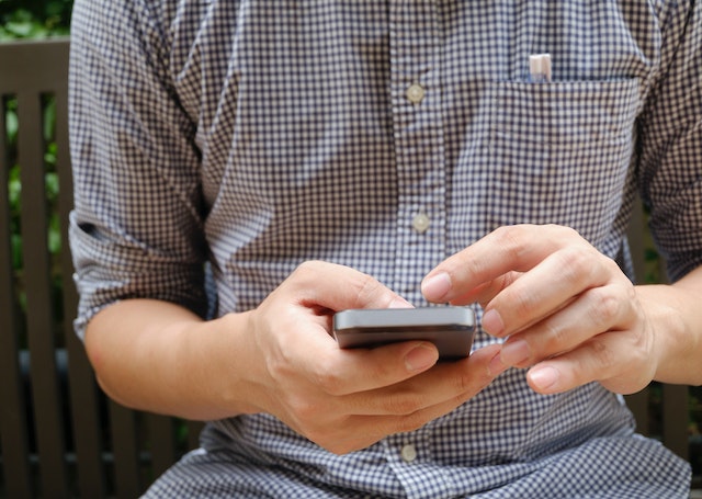 Pessoa que utiliza um smartphone para aprender a ler mensagens Instagram sem ser vista.