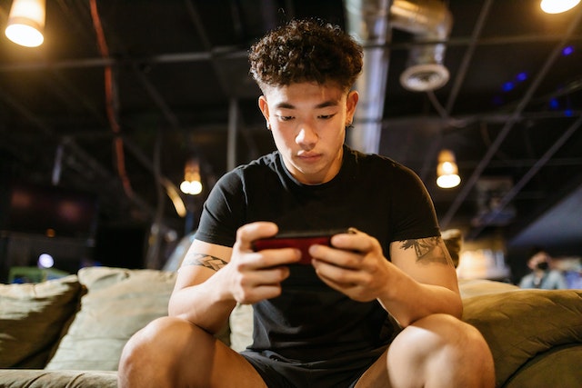 Young adult looking at a smartphone and playing Instagram games