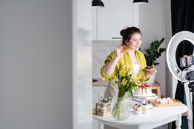 Makro-Influencerin, die ein Video in ihrer Küche für eine bezahlte Instagram-Partnerschaft dreht.