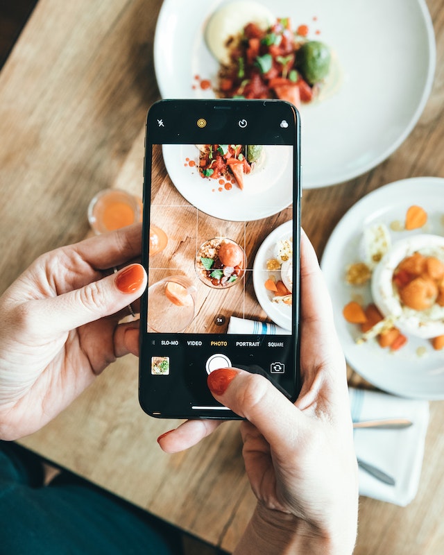 Instagram 、フォロワーと共有するために料理の写真を撮る人。