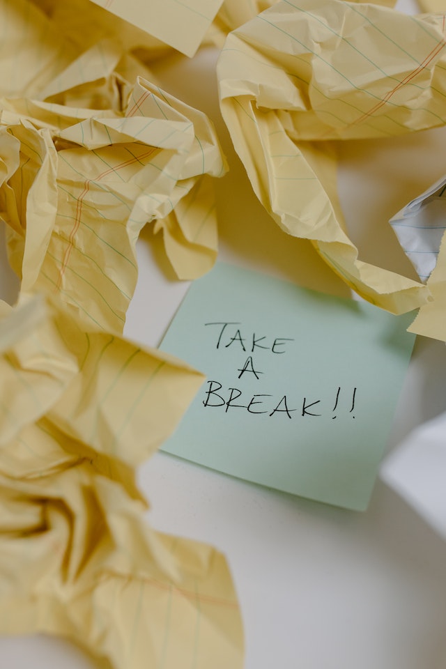 Gele verfrommelde plakbriefjes rond een groen plakbriefje met de tekst &quot;Take a Break!!!&quot;.