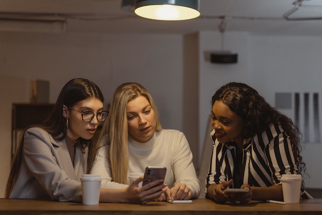 Femme montrant à ses amis comment obtenir des followers sur Instagram.