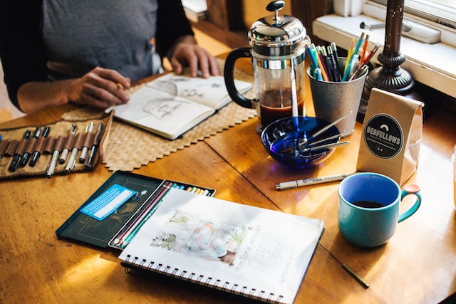 rachael-gorjestani-X6CZGpJBi8U-unsplash | Path Social Ein Künstler arbeitet an Skizzen, um Kunst auf Instagram zu verkaufen.