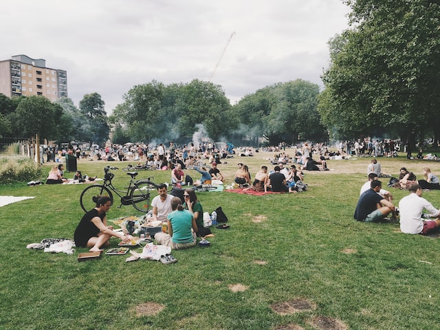芝生の上で輪になって座り、Instagram トレンドの話題について話し合う人々。