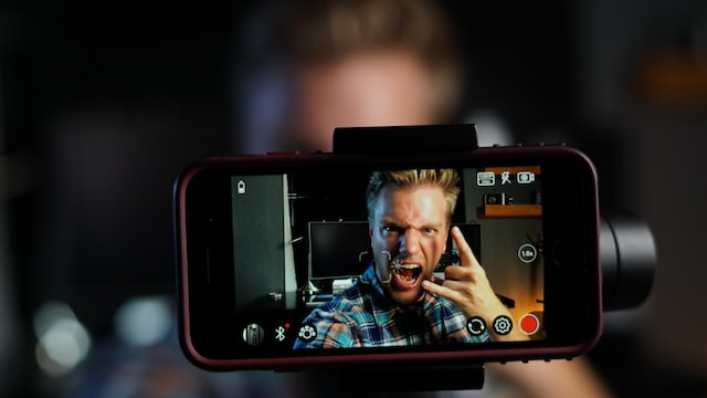 브이로거가 휴대폰 카메라 앞에 서서 Instagram 스토리를 위한 동영상을 촬영하고 있습니다.