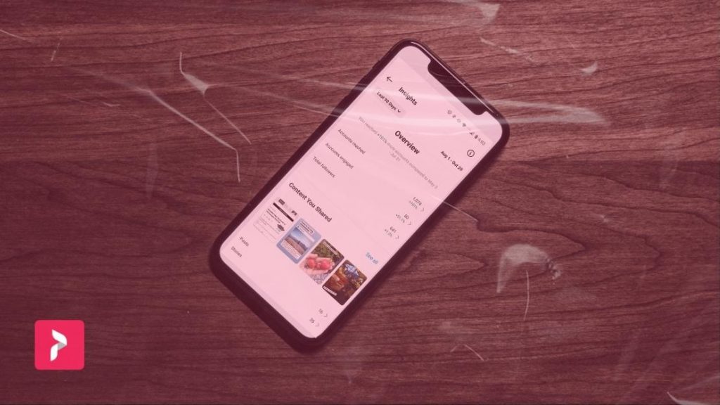 Logo-ul Path Social și un filtru roșu peste un telefon pe o suprafață de lemn cu Instagram Insights pe ecran.