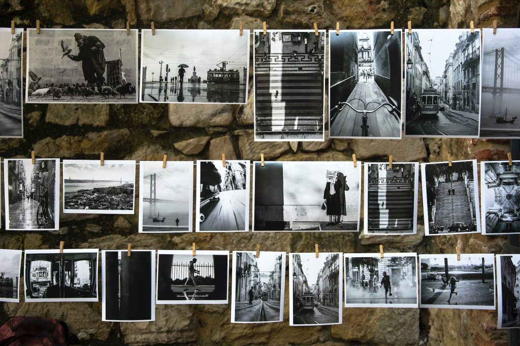 brigitta-schneiter-MHGDVDWjAb4-unsplash | Path Social Three rows of black and white Polaroid photos hanging on strings.