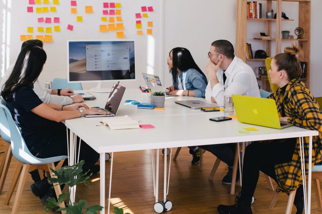 Website page showing a team of young professionals in a meeting.