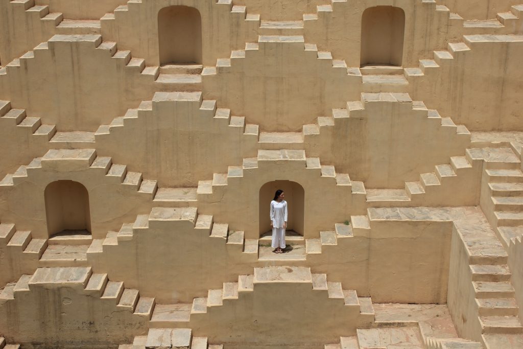 Femme debout au milieu d'un labyrinthe d'escaliers. 