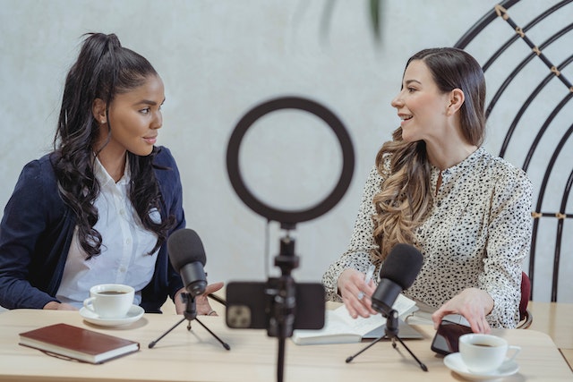 pexels-george-milton-6954174 | Path Social Two influencers discussing how to buy 100K Instagram followers.