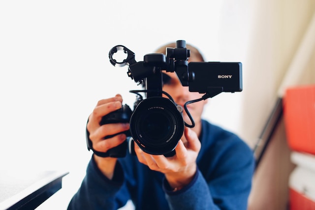 seth-doyle-3rcT6_NjjbU-unsplash-1 | Path Social A close-up of a man holding a professional video camera.