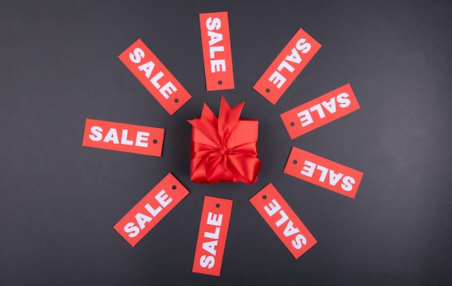 Red sale signs surrounding a package wrapped in red paper. 