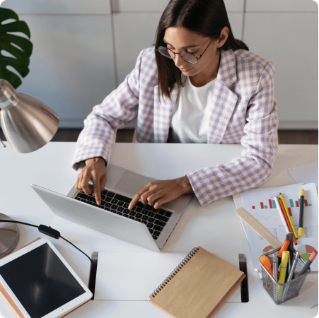 a woman sitting at a desk using a laptop