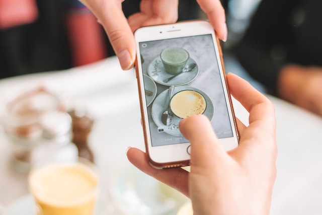  Person, die ein Foto von ihrem täglichen Kaffee für ihre Instagram Stories macht.