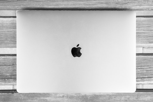 アップルのロゴが照らされたMacbookラップトップ。