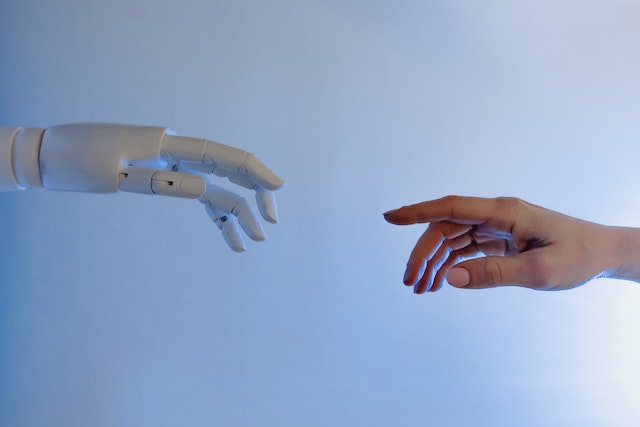 Robot hand reaches out to a human hand.