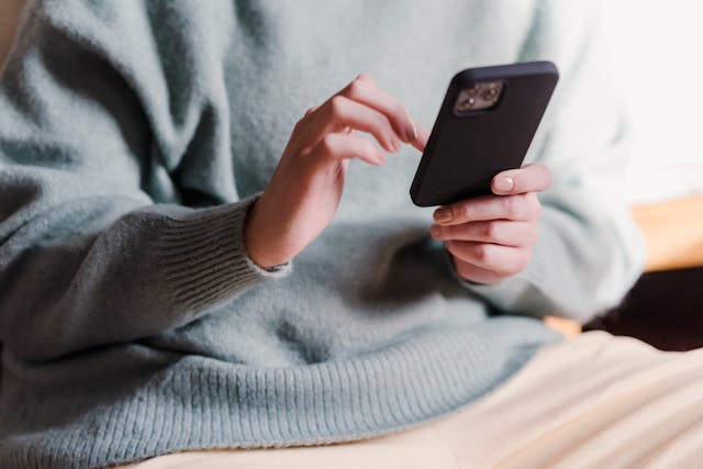 pexels-tim-samuel-6697306 | Path Social Fotografia de grande plano de uma pessoa a utilizar um smartphone preto.