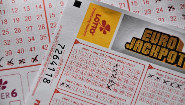 Bilhete de lotaria com números riscados.