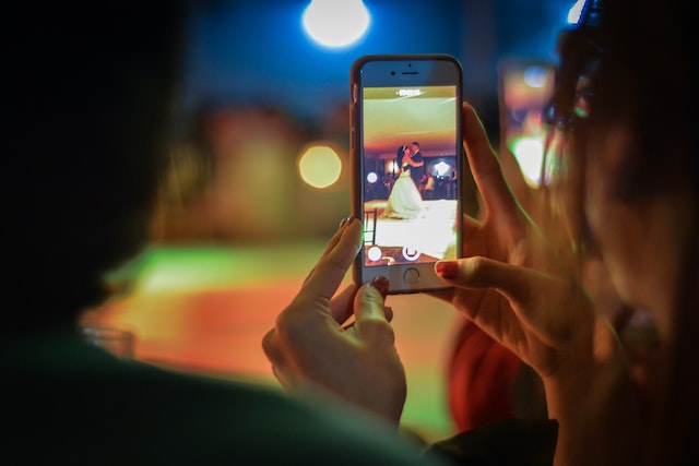 Nahaufnahme einer Frau, die nachts ein Mobiltelefon benutzt