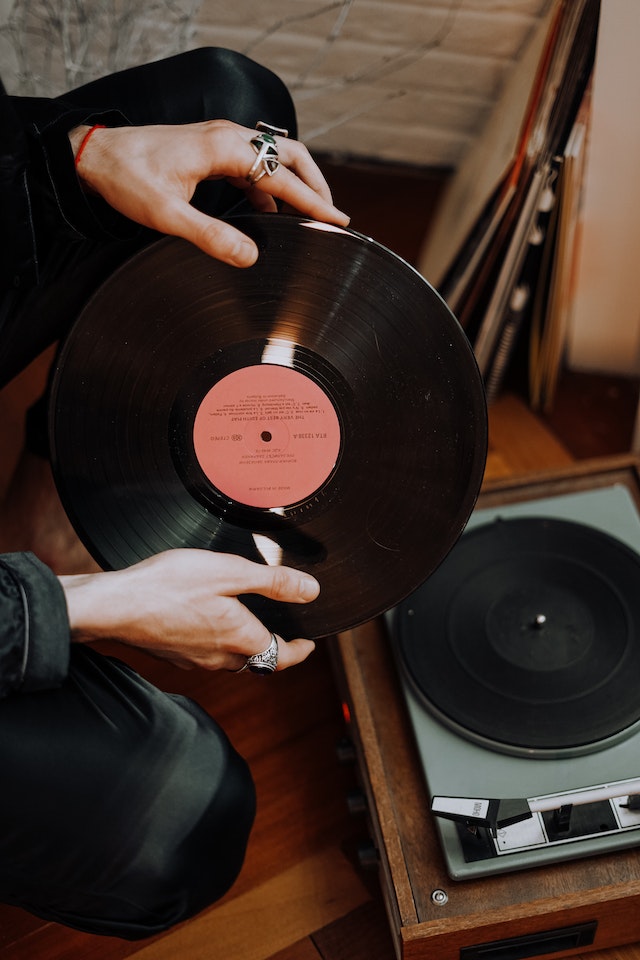 Manos sosteniendo un disco de vinilo.