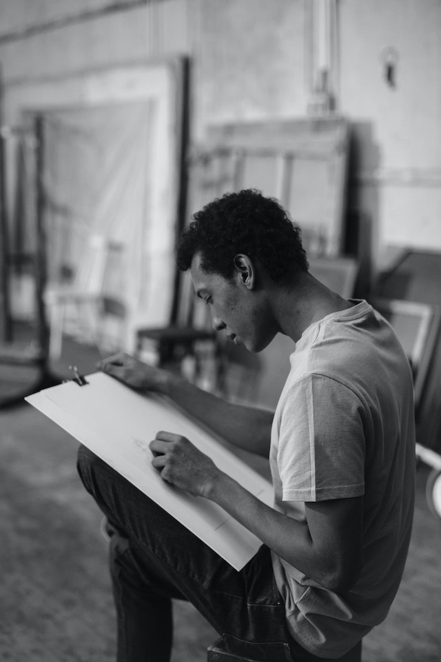 Homme faisant un croquis sur du papier à dessin.