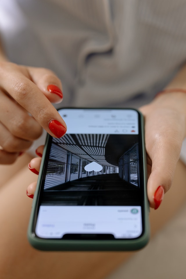 Frau drückt Like-Taste auf Instagram Feed auf schwarzem Telefon