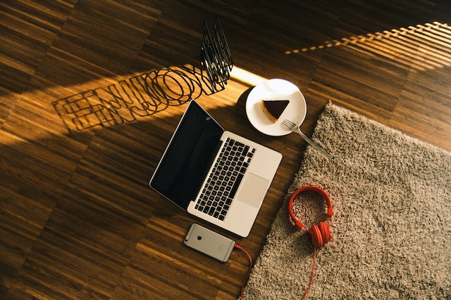 pexels-daniel-frank-586958 | Path Social جهاز Macbook بجانب شريحة على الكعكة على طبق، آي فون وسماعات رأس