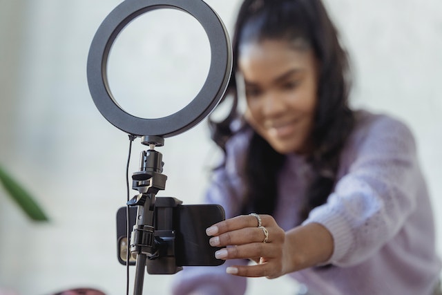 pexels-george-milton-6954220 | Path Social Woman sets up phone and ring light for pictures.